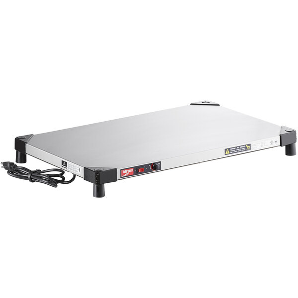 A stainless steel Metro countertop shelf warmer with black cords.