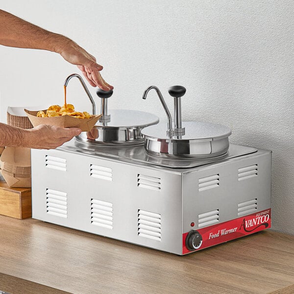 A person using an Avantco stainless steel condiment pump to pour food into a bowl on a counter.