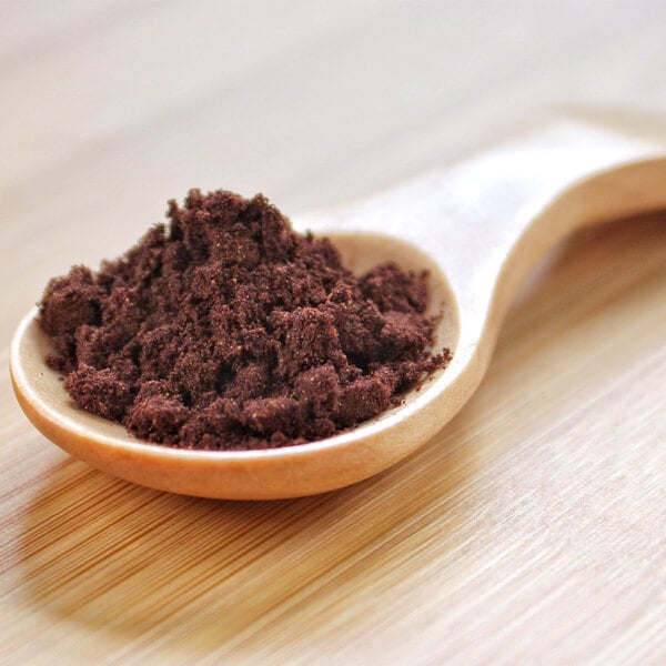 A wooden spoon filled with brown Calafate powder.