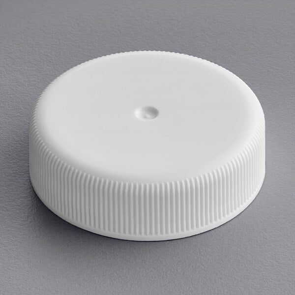 A 38/400 white plastic bottle cap on a white surface.