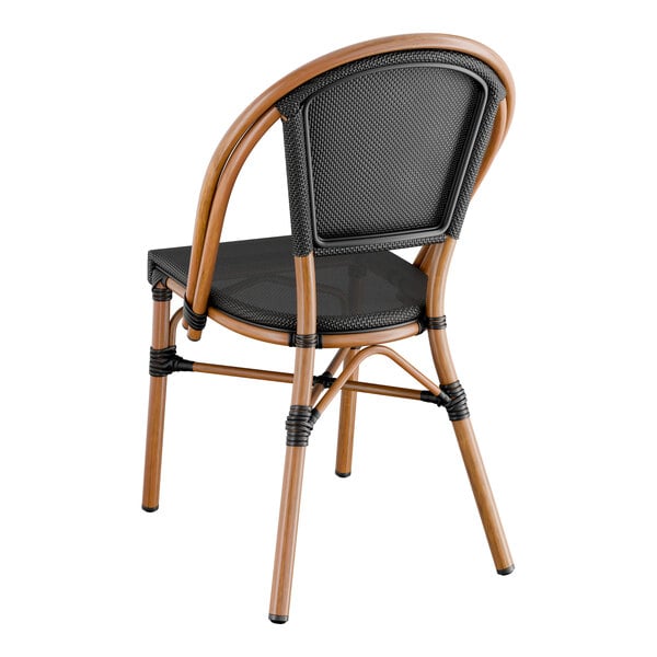 A Lancaster Table & Seating black Teslin outdoor side chair with wood accents and a black seat.