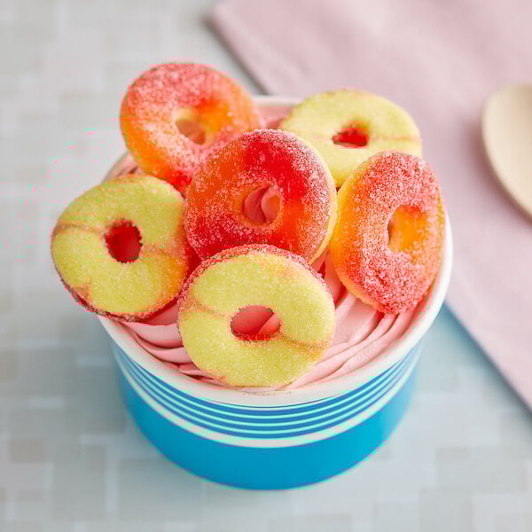A cup of ice cream with Vidal gummy peach rings on top.