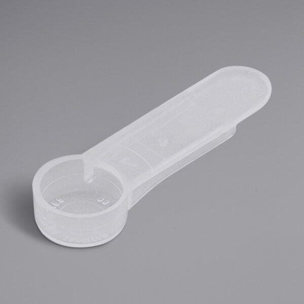 A close-up of a plastic measuring spoon with a short handle.