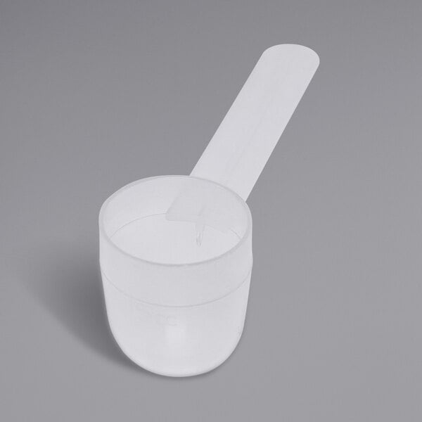 A white plastic measuring spoon with a long handle.