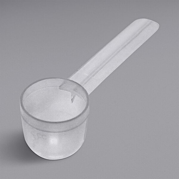 A clear plastic measuring spoon with a long handle.