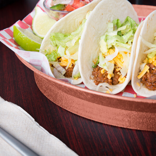 A plate of HS Inc. oval deli servers with tacos, limes, and a fork on a table.