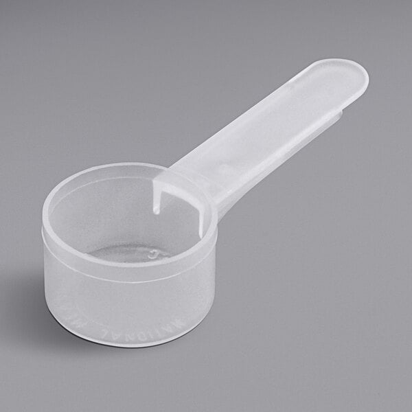 A white plastic measuring scoop with a handle.
