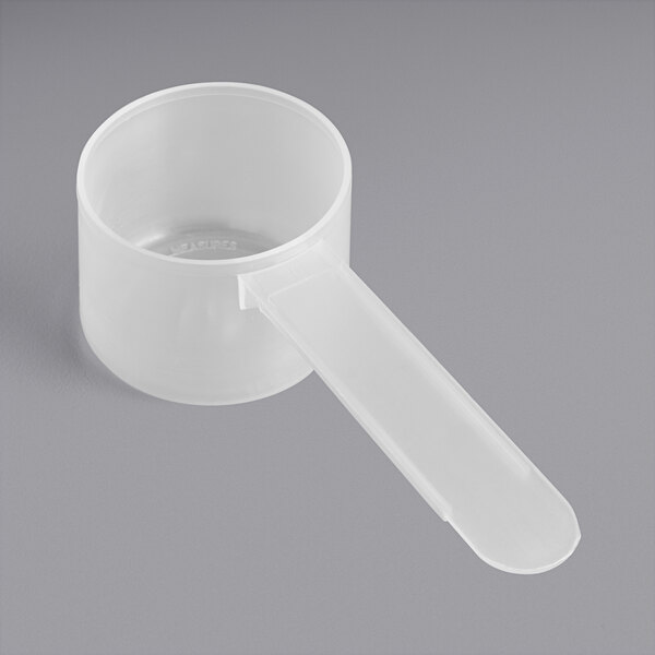 A white plastic measuring scoop with a long handle.