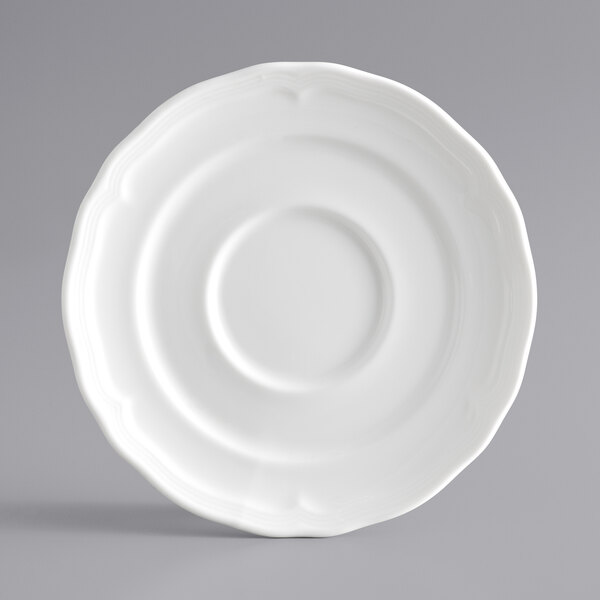 A white Acopa Condesa porcelain saucer with a scalloped edge.
