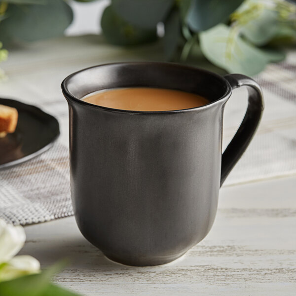 An Acopa Condesa armor gray porcelain mug filled with coffee on a table.