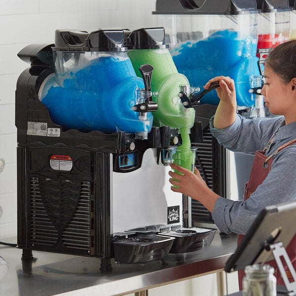 A woman pouring green slushy from a Carnival King slushy machine.