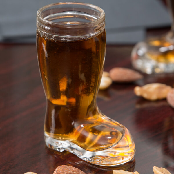 A Stolzle beer boot shot glass filled with beer.