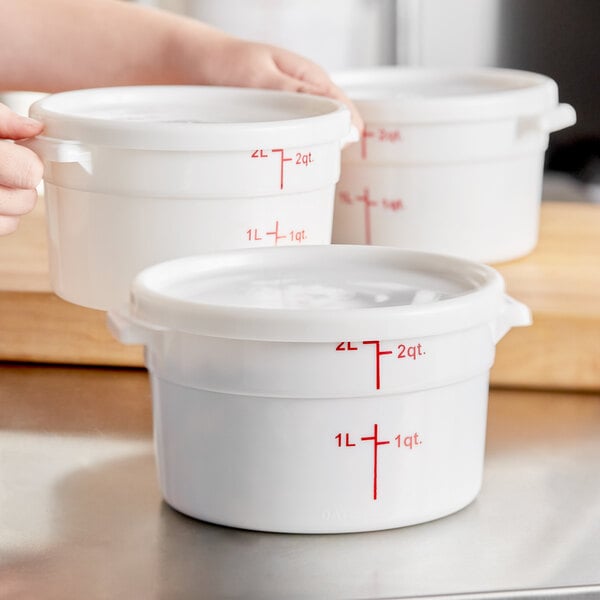 A woman holding a white Choice food storage container with a lid.