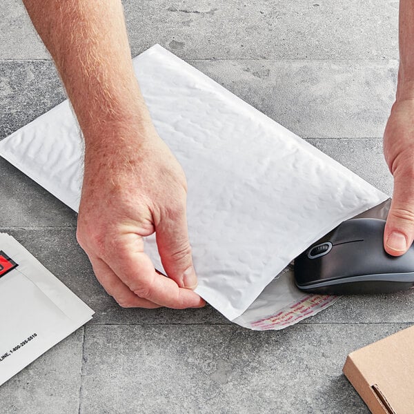 A hand holding a white Lavex Polyethylene Bubble Mailer envelope with black text.