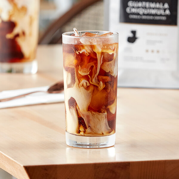 A glass of Arrosto Guatemala Chiquimula whole bean iced coffee on a table.