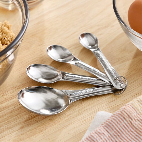 A set of four stainless steel measuring spoons connected by a metal ring.