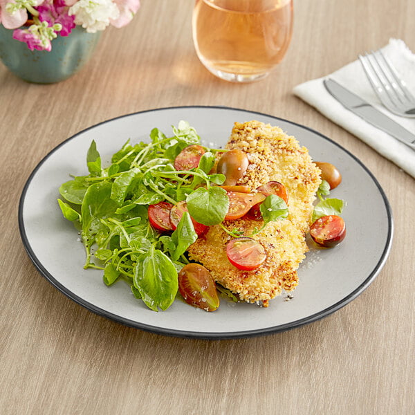 An Acopa Apollo matte grey and black melamine plate with chicken, tomatoes, and greens on it.