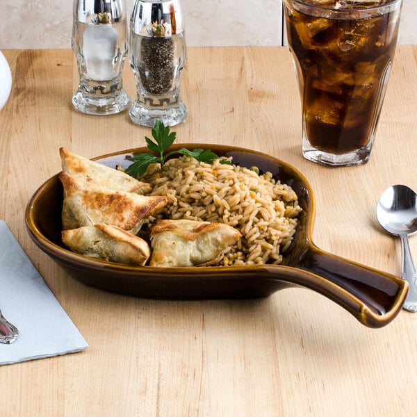 A Tuxton caramel china bowl filled with rice and chicken on a table.