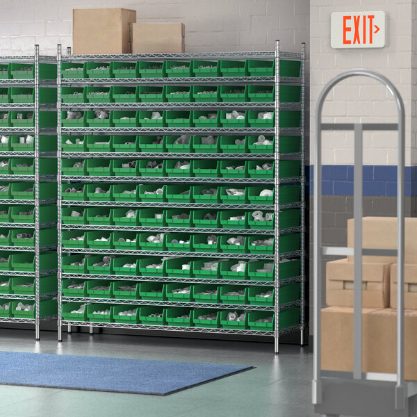 A warehouse with Regency wire shelving filled with green storage bins.