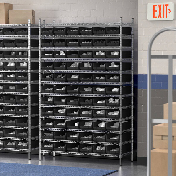 A Regency wire shelving unit with many black bins.