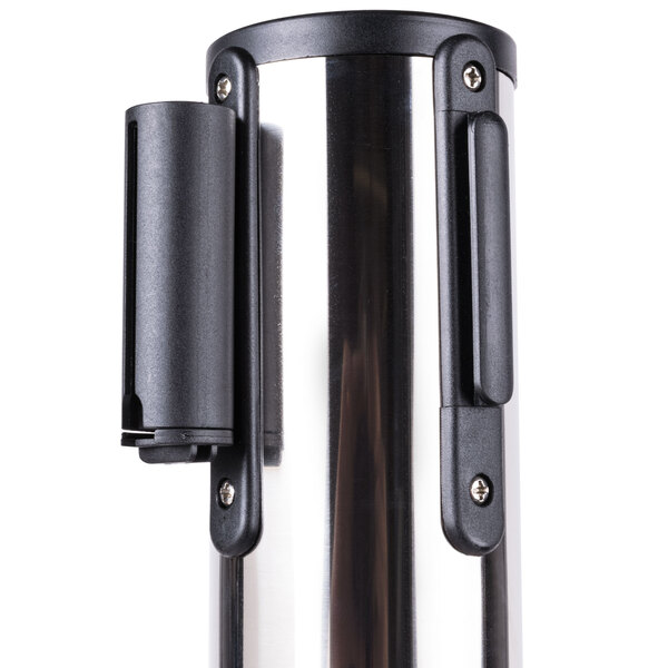 A chrome Aarco crowd control stanchion with red retractable belts.