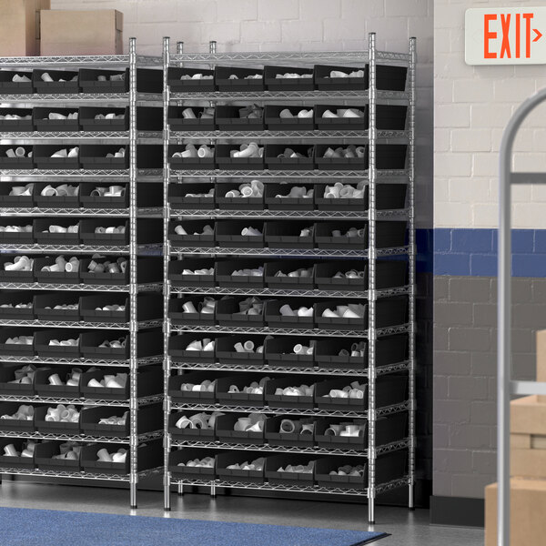 A Regency wire shelving unit with many black bins on the shelves.