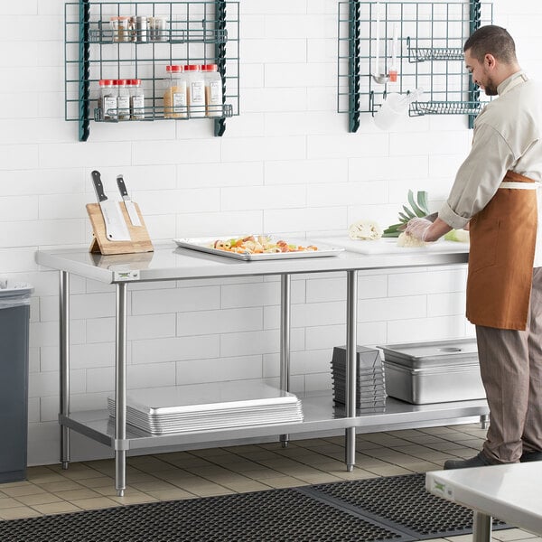 A man in an apron at a Regency stainless steel work table with undershelf.