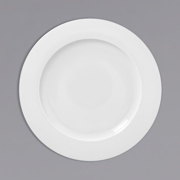 A white plate with a wide rim on a gray background.