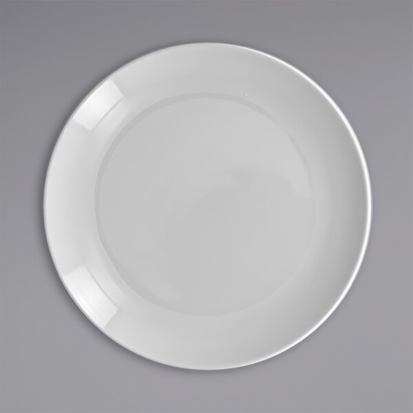 A close up of a white RAK Porcelain flat coupe plate with a circle in it.