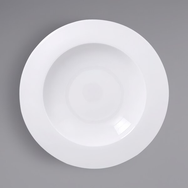 A white plate with a wide rim on a white surface.