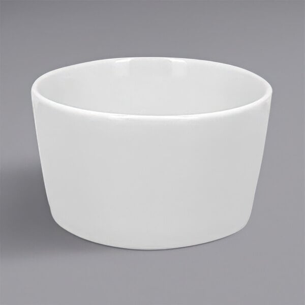 A RAK Porcelain white cream soup bowl on a gray surface.