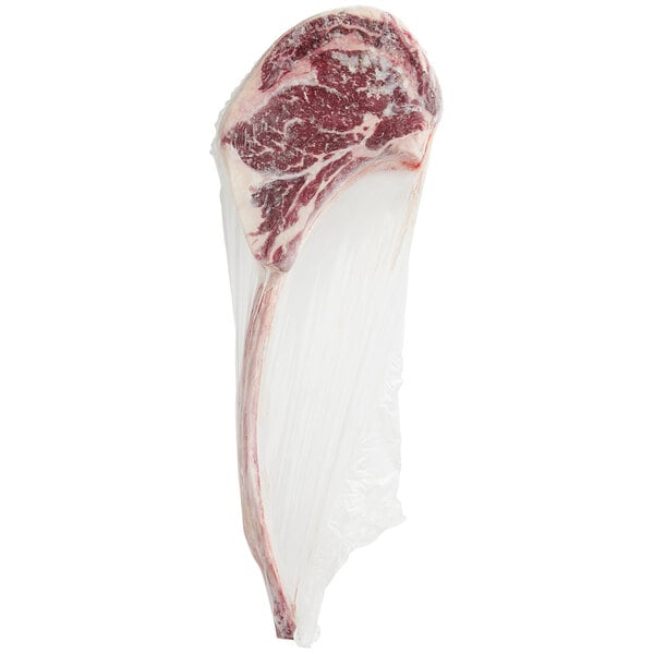 A Rastelli's Black Angus bone-in tomahawk steak wrapped in plastic.
