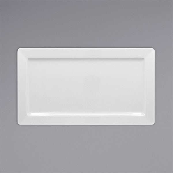 A white rectangular RAK Porcelain Polaris plate with black edges on a gray surface.