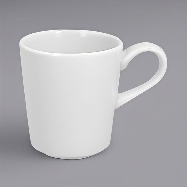 A close-up of a white RAK Porcelain espresso cup with a handle.