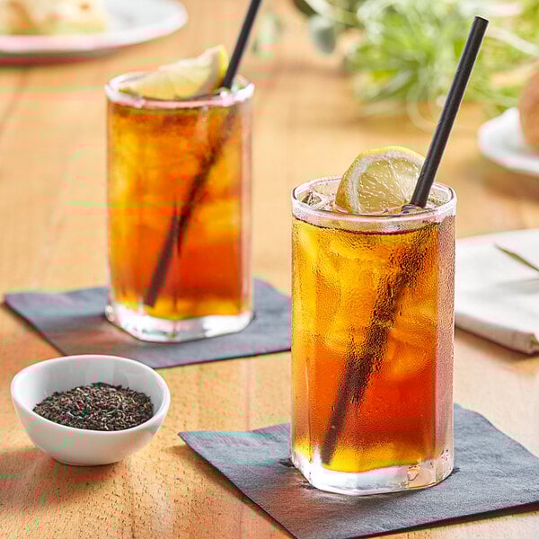 Two glasses of Tractor Beverage Co. Organic Unsweet Tea with lemon slices and straws.