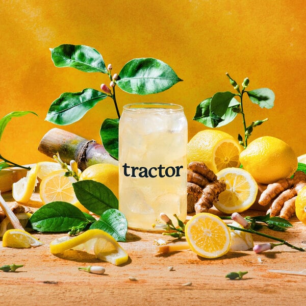A glass of Tractor Beverage Co. lemonade with a lemon wedge.