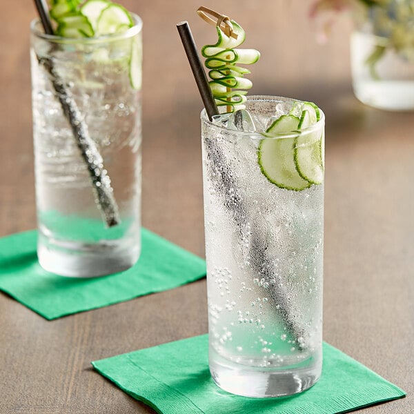 Two glasses of water with cucumber slices and straws on a table.