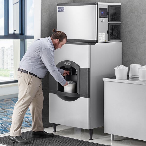 A man using an Avantco Ice machine to fill a bucket with ice.