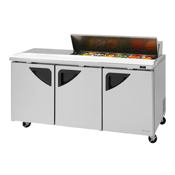 A Turbo Air stainless steel refrigerated sandwich prep table with three doors and a left work station.