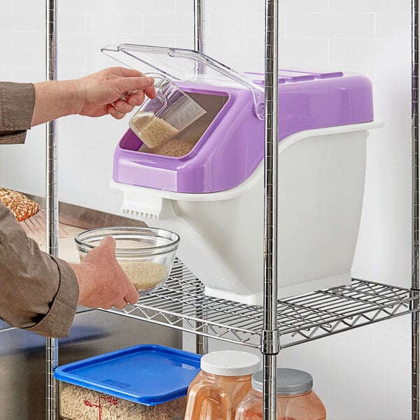 A person pouring rice into a white and purple Baker's Lane ingredient bin.