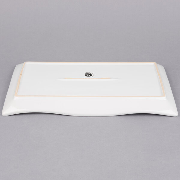 A white rectangular stoneware platter with a wavy border and a logo on it.
