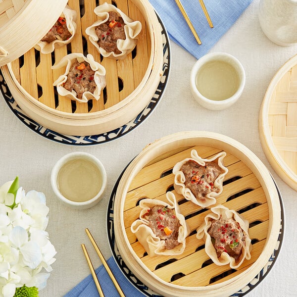 A wooden table with a bowl of ground venison and two bowls of food.