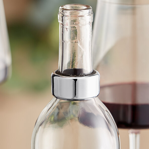A stainless steel and black felt wine collar on a wine bottle.