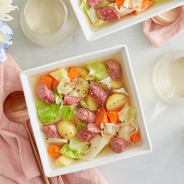 A bowl of soup with smoked venison sausage, cabbage, and meat.