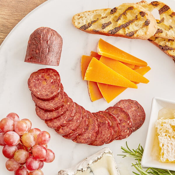 Slices of Shaffer Venison Farms venison cheddar summer sausage and cheese on a plate.