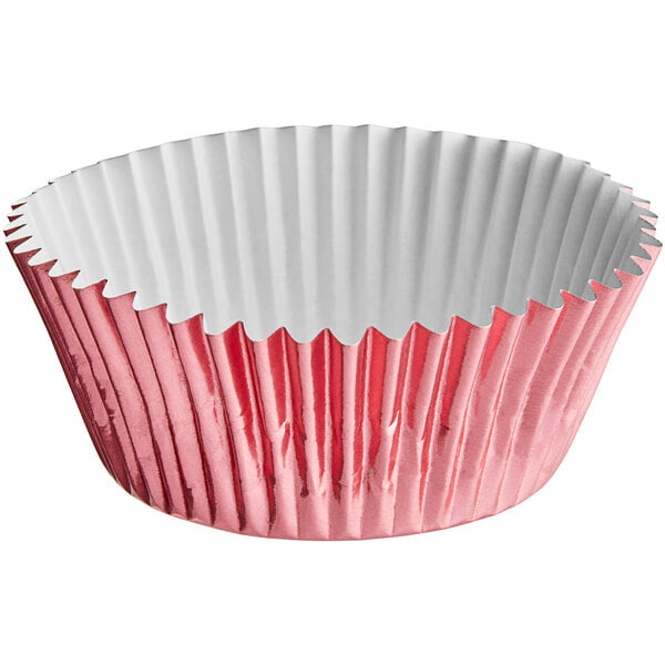 A pink and white Enjay foil baking cup in a cupcake pan.