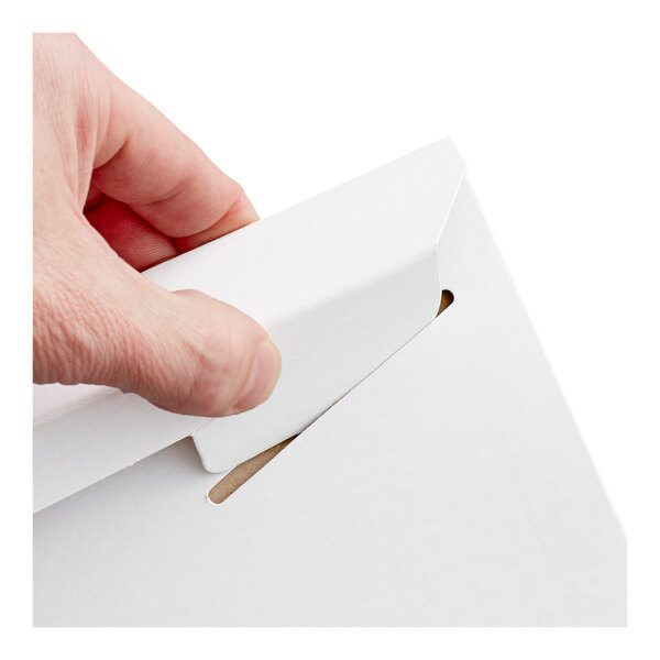 A white tab-locking rigid mailer being closed by hand.
