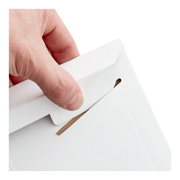 A white tab-locking rigid mailer being closed by a hand.