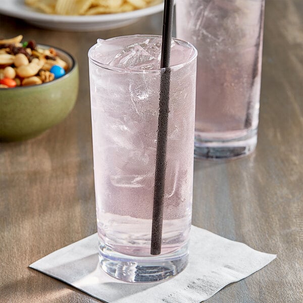 A glass of Jones Watermelon Vitamin Water with a pink drink and a black straw.