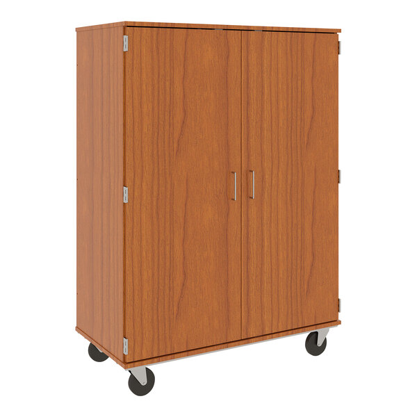 A wooden cabinet with two closed doors on wheels.